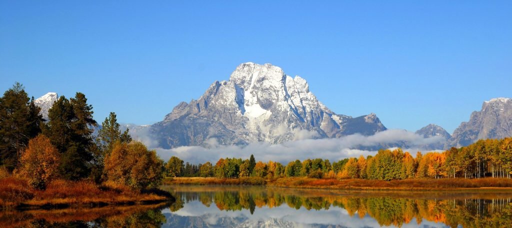 A mountain range reflected in still water.