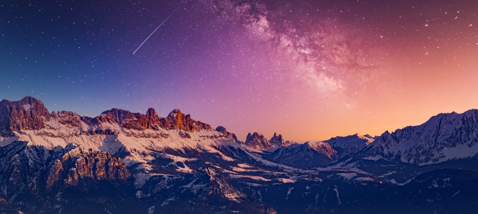 A snow-covered ridge under a night sky.